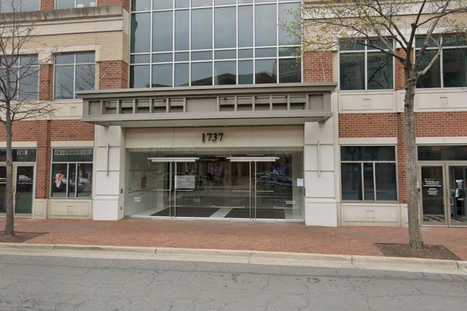Street view of 1737 King Street: a brick and glass building with a recessed glass entrance under a grey canopy, the number 1737 above the doors